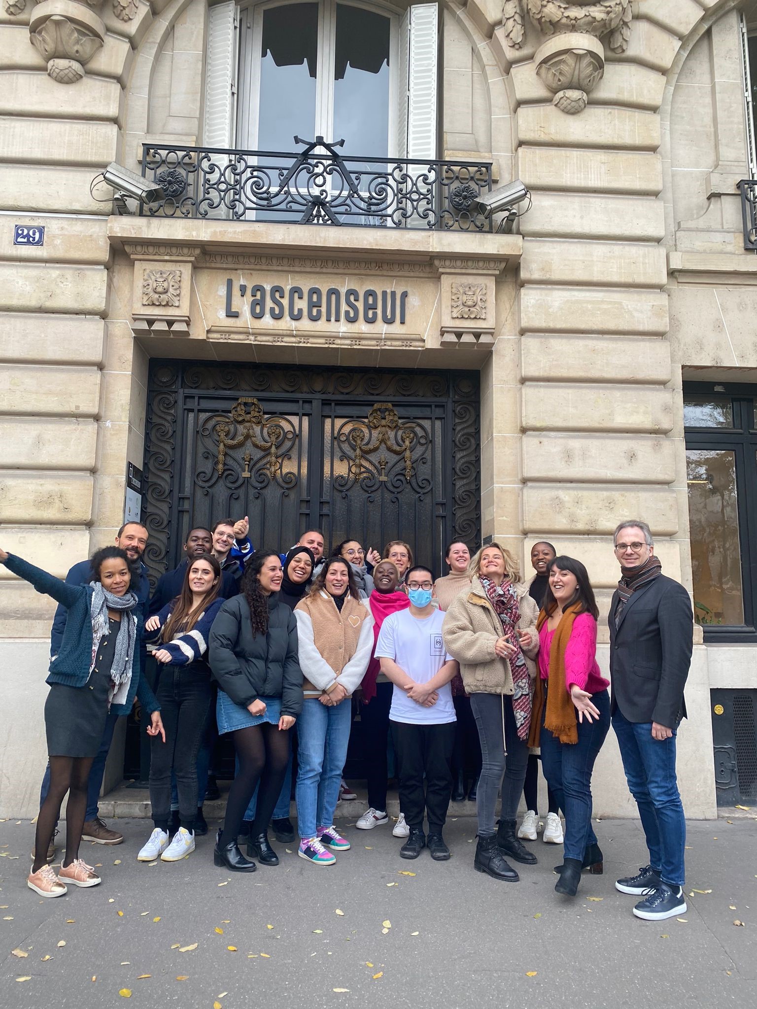 Image décorative d'un groupe d'individus devant la porte d'entrée de l'Ascenseur à Bastille.